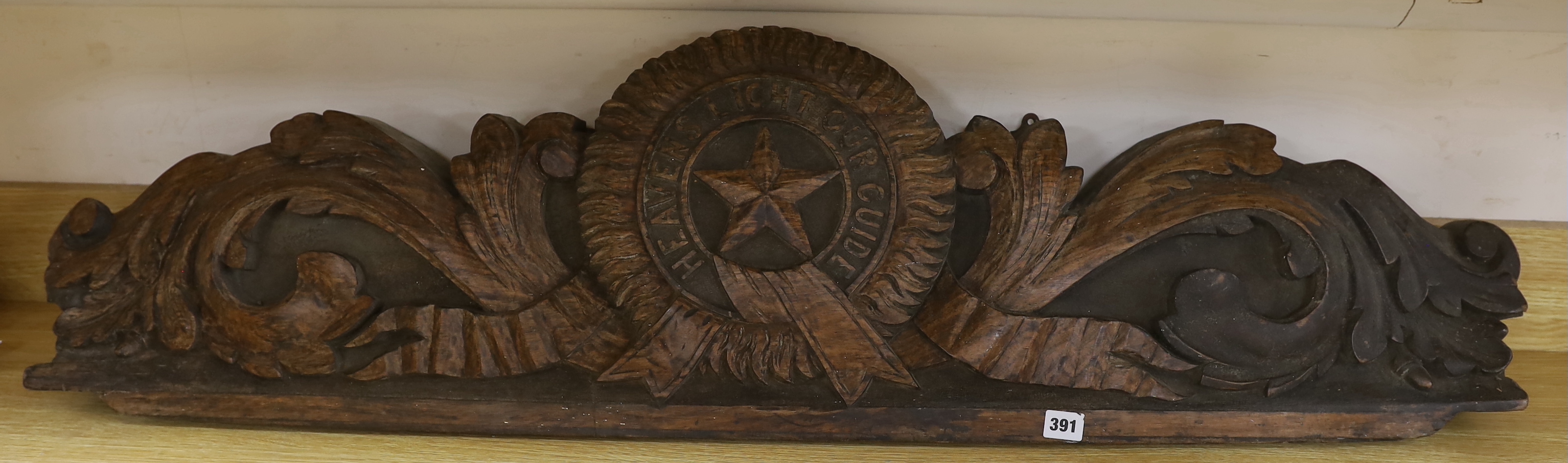 An Anglo-Indian carved hardwood panel with inscribed motto ‘Heavens Light Our Guide’, The motto for the order of the star of India, 123cm long